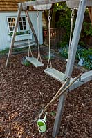 A view of a double wooden swing set.