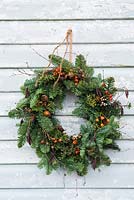 Traditional pine wreath with dried decorative accessories. 