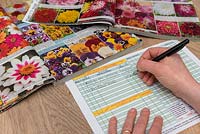 Person ordering floral seeds from a catalogue. 