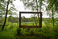 Suspended picture frame in woodland fringe. 