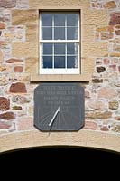 Sundial inscribed by Michael Harvey above brick arch. 