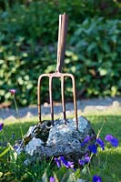 Old garden fork embedded in stone, Argyll, Scotland, UK