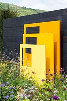 Yellow steel sculptural panels with black fence background - 'Urban Oasis', RHS Malvern Spring Festival 2018.