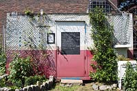 Tool shed with blackboard on the door, The Growing Kitchen Community Garden, Hoxton, London, UK.