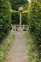 View down path leading to the stone sundial at York Gate Garden, Leeds, Yorkshire, UK. 