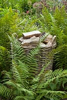 Decorative log basket in the Canal Garden at York Gate, Leeds, Yorkshire, UK. 