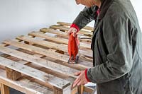 Using a jigsaw to cut wooden pallet
