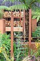Veronicastrum virginicum 'Album' with reclaimed, rusted drainage pipes and Corten water container, Dicksonia antarctica in background - Bee's Gardens: The Penumbra, RHS Tatton Park Flower Show 2018