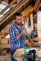 Chris Punch, garden furniture designer in his workshop preparing wood