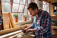 Chris Punch, garden furniture designer, in his workshop preparing wood. 