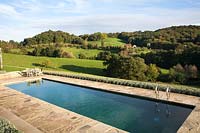 An outdoor swimming pool edged with sandstone and with view of rolling 
countryside beyond