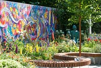 The Supershoes, Laced with Hope Garden, a partnership with Frosts. Sponsor: Frosts Garden Centres, RHS Chelsea Flower Show, 2018. Mural by Karen Huwen. 