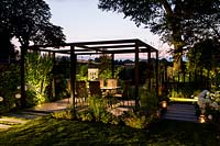 Artificial light with pergola and patio seating.
