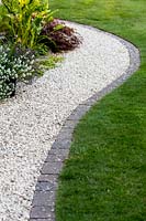 Curved gravel path with stone sett edging and lawn - Pam Woodall's garden, 'Pinecombe' in Dorset, UK