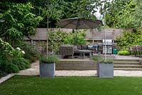 Large garden in St John's Wood with artificial lawn and raised deck seating area 
 with barbecue 