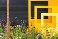 Yellow steel sculptural panels with black fence and meadow-style planting - 'Urban Oasis', RHS Malvern Spring Festival 2018.