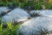 Stepping stones and marginal planting in show garden - Elements Mystique Garden, Sponsored by Elements Garden Design, RHS Hampton Court Flower Show, 2018. 