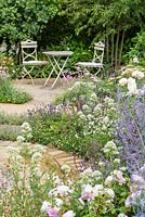 Roses and Perovskia with table and chairs. 'Best of Both Worlds', RHS Hampton Flower Show, 2018 
