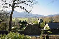 View down over the buildings and gardens of Plas Brondanw from the wooded hillside above. Plas Brondanw, Penrhyndeudraeth, Gwynedd, Wales 