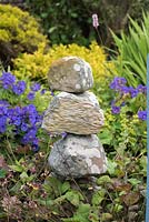 A stone tower rests near Geranium magnificum.