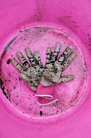 Garden gloves in bottom of pink garden trug. 