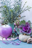 Purple, white and blue autumnal arrangement, with pumpkins, ornamental cabbages and Pernettya.