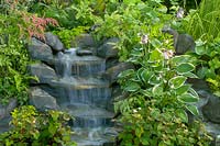 Tumbling stream surrounded with Hostas and ferns. The Harmony Garden. Hampton Court Flower Show, 2003, London, UK. 