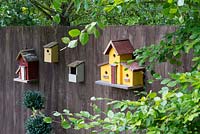Collection of Birdhouses on a wooden fence. 