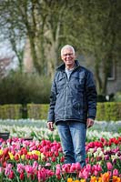 Man standing in bed of Tulipa - tulips