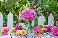 Flower arrangement with hydrangea and roses in garden table. 