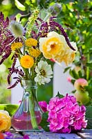 Summer floral arrangement in glass vase with Rosa, Hydrangea, Amaranthus, Zinnia, Dipsacus, Verbascum and Achillea.  