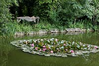 The 'Levitating Lady' made by Bloomsbury artist Quentin Bell, looks out across a pond with waterlilies.