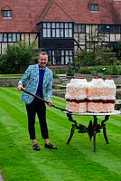 Florist Simon Lycett cuts large floral cake, made with Dianthus 'Apple Juice', Rosa 'Tamango', Hydrangea macrophylla 'Alba' and Rosa 'Naomi'.
