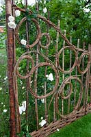 Hazel and willow decorative fence in pattern of circles in the show garden Belmond Enchanted Gardens 