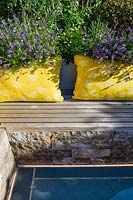 An integral bench and raised flower bed, surrounded by flowering Lavandula - Lavender. 