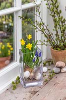 Finished arrangement with Narcissus 'Tete a Tete', Muscari, feathers and eggs.