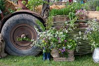 Wildflowers on 'Sophie's country Garden Flowers' display with woven fence panel and tractor