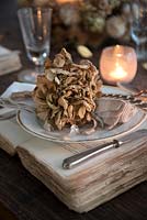 Dried Hydrangea flowerhead place setting on vintage book charger