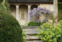 The Casita with pink  marble Verona columns and flowering wisteria at Iford Manor, Bradford-on-Avon, Wiltshire, UK. 