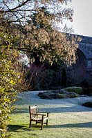 Wooden bench sits on frosted lawn at Kilver Court, Somerset, UK. Designed by Roger Saul of Mulberry.