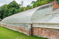 Restored iron-framed curvilinear glasshouses. Wildegoose Nursery, The Walled Garden, Lower Millichope, Munslow, Shropshire, UK. 