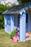 Blue painted children's playhouse in garden. 