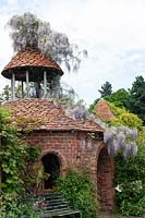 Folly tower covered in Wisteria at Stone House Cottage Garden, June