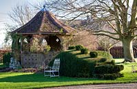 A Dragon of clipped Yew snakes around the Gazebo at Stevington Manor Garden, Stevington, UK.