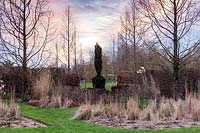 View to Topiarised Taxus baccata 'Fastigiata' based on 'Broken Obelisk' by Barnett Newman. The Art Gardens, Stevington Manor Gardens, Stevington, UK. 