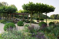 Wooden pergola offering shade over dining area. 