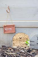 Hedgehog hole in fence gravel board, marked with sign.