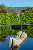 'Zephyr' by Simon Gudgeon overlooking a reflective pool with split boulder - The Leaf Creative Garden , A Garden of a quiet contemplation - RHS Malvern Spring Festival 2019