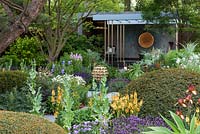 The Morgan Stanley Garden. An herbaceous rich space punctuated by large yew topiary domes and specimen trees, a path leading to a relaxation pod for quiet reflection. Sponsor:  Morgan Stanley. RHS Chelsea Flower Show 2019.