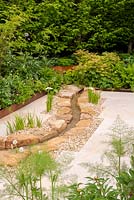 Stream with Iris laevigata surrounded by beds with copper coloured edging -Kampo no Niwa, RHS Chelsea Flower Show 2019